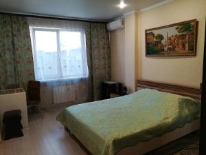 a hotel room with a bed and a window at Hotel Uyut in Lipetsk