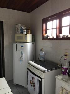 eine Küche mit einer Mikrowelle auf dem Kühlschrank in der Unterkunft Casa aconchegante - Búzios in Búzios