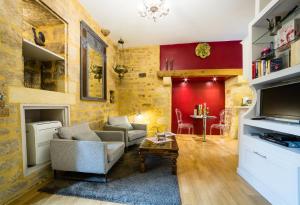 un soggiorno con pareti rosse, divano e tavolo di Rouge Passion a Sarlat-la-Canéda