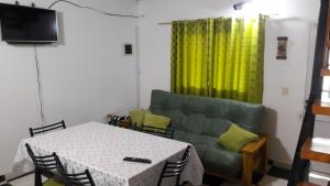 - un salon avec une table et un canapé vert dans l'établissement Apartamento Duplex Iguazu Falls, à Puerto Iguazú