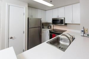 eine Küche mit einer Spüle und einem Kühlschrank aus Edelstahl in der Unterkunft Serene Condo in SF/North Beach/Telegraph Hillside in San Francisco