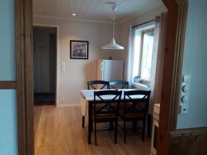 a kitchen with a table and chairs and a refrigerator at Grimsøy Lofoten House in Saupstad