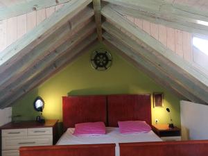 a bedroom with a bed with pink pillows on it at Buena Vis-ta Apartments with the Sea View in Vis