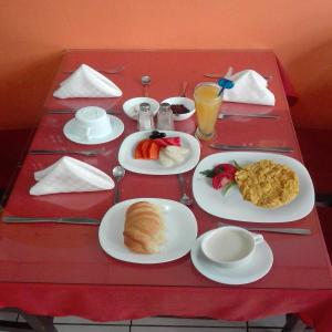 a table with plates of food on a red table at Hotel El Ejido in Quito