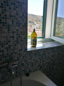 a bottle sitting on a window sill next to a sink at Buena Vis-ta Apartments with the Sea View in Vis