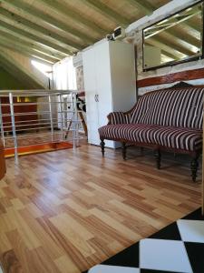 a living room with a couch and wooden floors at Buena Vis-ta Apartments with the Sea View in Vis