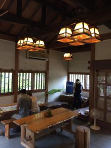 um grupo de pessoas sentadas numa sala com uma mesa em Otsu Nature Garden em Akiruno
