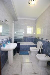 a bathroom with a sink and a toilet and a tub at Villa do Lago in Silves