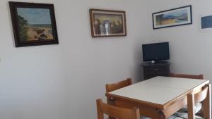 a dining room with a table and a tv at Appartamento sul Tramonto in Chiessi