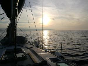 un barco en el océano con la puesta de sol en Buena Vis-ta Apartments with the Sea View en Vis