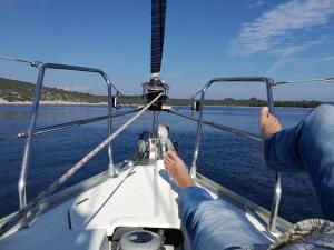 two people on a boat in the water at Buena Vis-ta Apartments with the Sea View in Vis