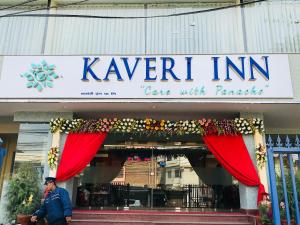 a man walking in front of a cafe with a sign at Kaveri Inn in Kathmandu
