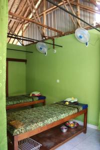 a room with two bunk beds in a green wall at Taman Sandat in Amed