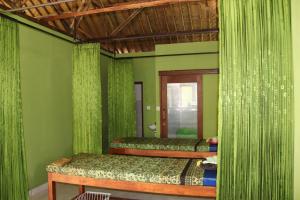 two beds in a room with green curtains at Taman Sandat in Amed +15 photos