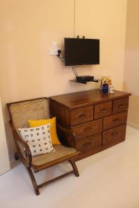 a room with a dresser and a chair with a television at Araliya Suite in Nugegoda