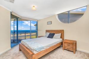 a bedroom with a bed and a large window at Sail Away in Aldinga Beach