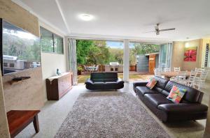 a living room with a couch and a table at Crescent Head Spa Villa in Crescent Head