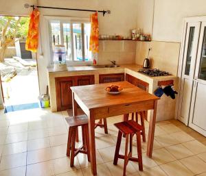eine Küche mit einem Holztisch mit einer Obstschale darauf in der Unterkunft Villa A.TIA in Morondava