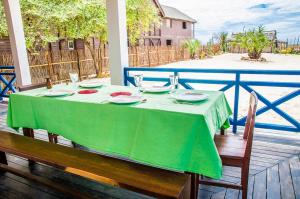 einen Tisch mit einem grünen Tischtuch auf einer Veranda in der Unterkunft Villa A.TIA in Morondava