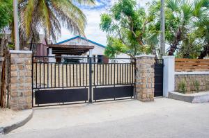a black gate in front of a house with palm trees at Villa A.TIA in Morondava