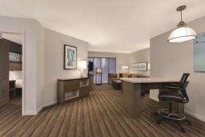 a hotel room with a desk and a bedroom at Hyatt House Cypress / Anaheim in Cypress