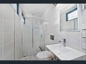 a bathroom with a shower and a toilet and a sink at Crescent Head Spa Villa in Crescent Head