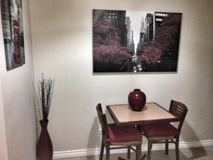 a table and chairs with a vase on top of it at 1-Bedroom Cozy Suite #23 by Amazing Property Rentals in Gatineau