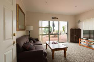 een woonkamer met een bank en een salontafel bij Ocean View B&B in Whitianga
