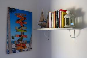 a shelf with books and a lamp on a wall at Il Capperino in Capoliveri