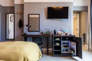 Dormitorio con cama, escritorio y TV en The Brewers Inn, en Londres