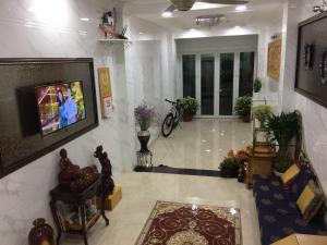 ein Wohnzimmer mit einem TV an der Wand in der Unterkunft The Moana House in Ho-Chi-Minh-Stadt