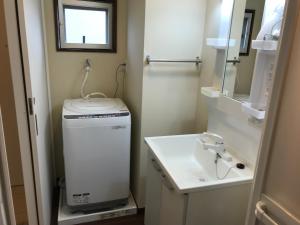 a small bathroom with a sink and a washing machine at Weekly Harbourview Mansion Ginowan in Ginowan +27 photos