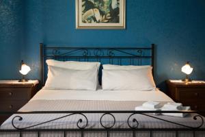 1 dormitorio con 1 cama con paredes azules y 2 lámparas en Catania Inn Rooms, en Catania