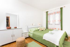 biała sypialnia z łóżkiem i lustrem w obiekcie Apartment Penetra w mieście Cavtat