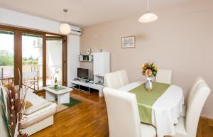 sala de estar con mesa de comedor con sillas blancas en Apartment Penetra, en Cavtat