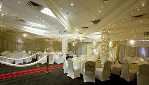 a banquet hall with white tables and white chairs at Coastlands Durban Self Catering Holiday Apartments in Durban