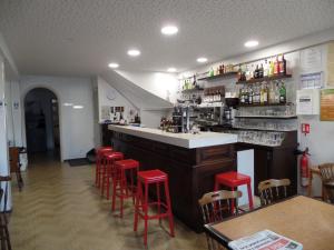 un bar dans un restaurant avec tabourets rouges dans l'établissement Auberge Saint Jacques, à Saint-Alban-sur-Limagnole