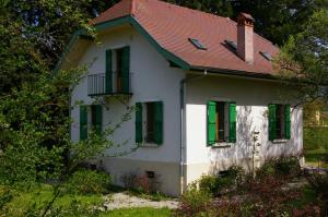 a white house with green shutters and a red roof at Angel Services - Le Nant in Saint-Jorioz
