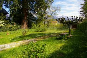 a park with a picnic table and benches in the grass at Angel Services - Le Nant in Saint-Jorioz +8 photos