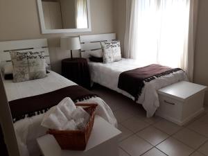 a bedroom with two beds and a window at The Upper Deck Apartment in Swellendam