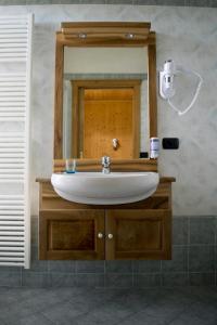 a bathroom with a sink and a mirror at B&B Affittacamere Larix in Rumo