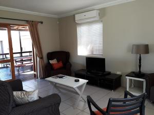 a living room with a couch and a table at The Upper Deck Apartment in Swellendam