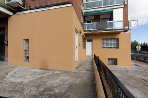 un bâtiment jaune avec une clôture à côté dans l'établissement WindRose 2, à Madrid