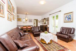 a living room with leather furniture and a table at Holiday Home Field of Olives in Gruda