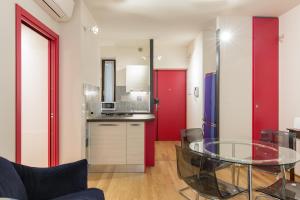 ヴェローナにあるCasa Sottorivaの赤いドアとガラスのテーブル付きのキッチン