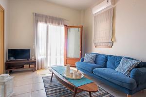 a living room with a blue couch and a table at Sody Magnificent Bay View in Chania