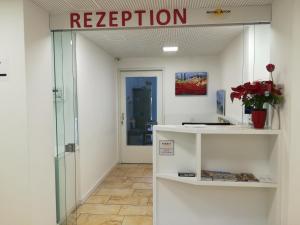 a reception area in a building with a sign on the wall at Hotel Aton in Graz