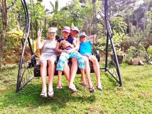 a group of people sitting on a swing at Sunny Side Villa in Tangalle