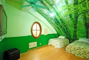 a green room with two beds and a mirror at Maison-Philo Homestay B & B in Sanyi