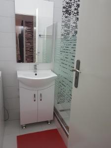 ケストヘイにあるZorka Apartmanの白いバスルーム(シンク、シャワー付)